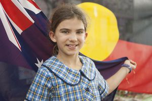 St Mary - St Joseph Catholic Primary School Maroubra - student in front of Australian and Aboriginal flag